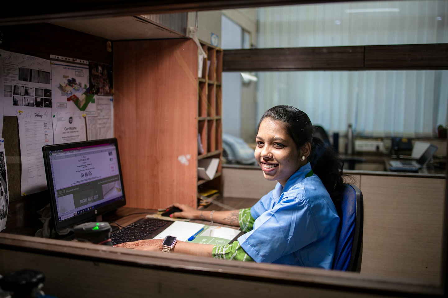 Femme en uniforme bleu travaillant sur son ordinateur de bureau.
